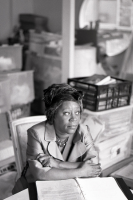 Black and white photo of Dame Professor Sonia Boyce DBE RA, sitting at her desk